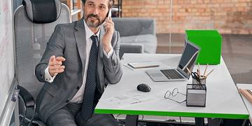 Een directeur, achter zijn bureau aan het bellen.