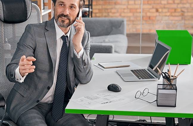 Een directeur, achter zijn bureau aan het bellen.